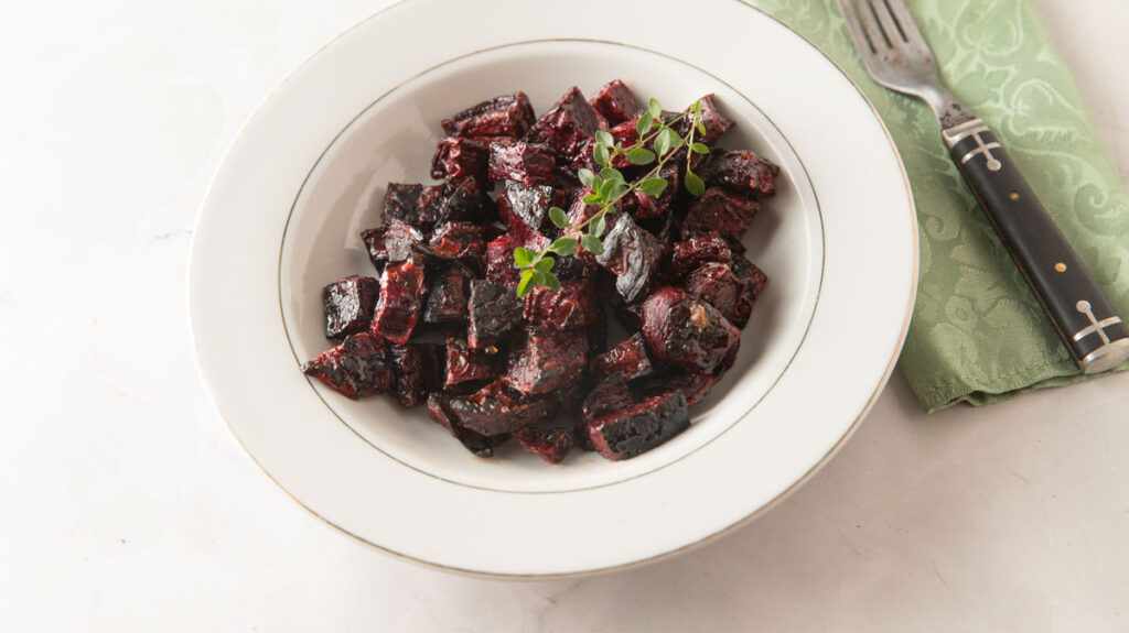 Roasted beets in a white bowl.