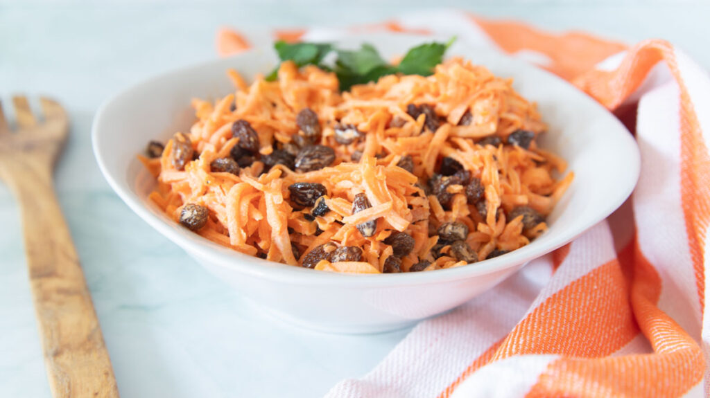 A bowl of Carrot Raisin Salad.
