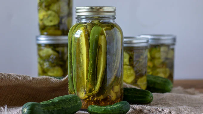 Jars of sweet pickles on burlap.