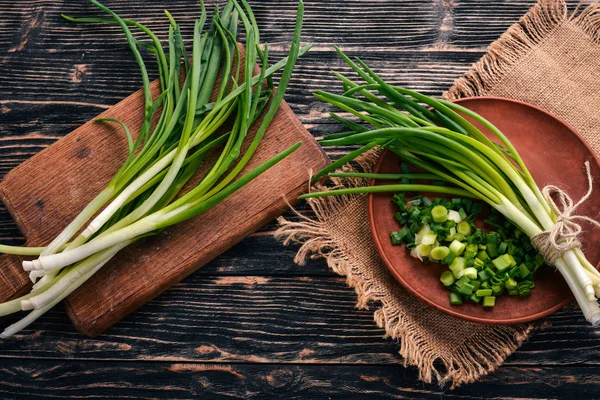 Fresh green onion on a wooden background.
