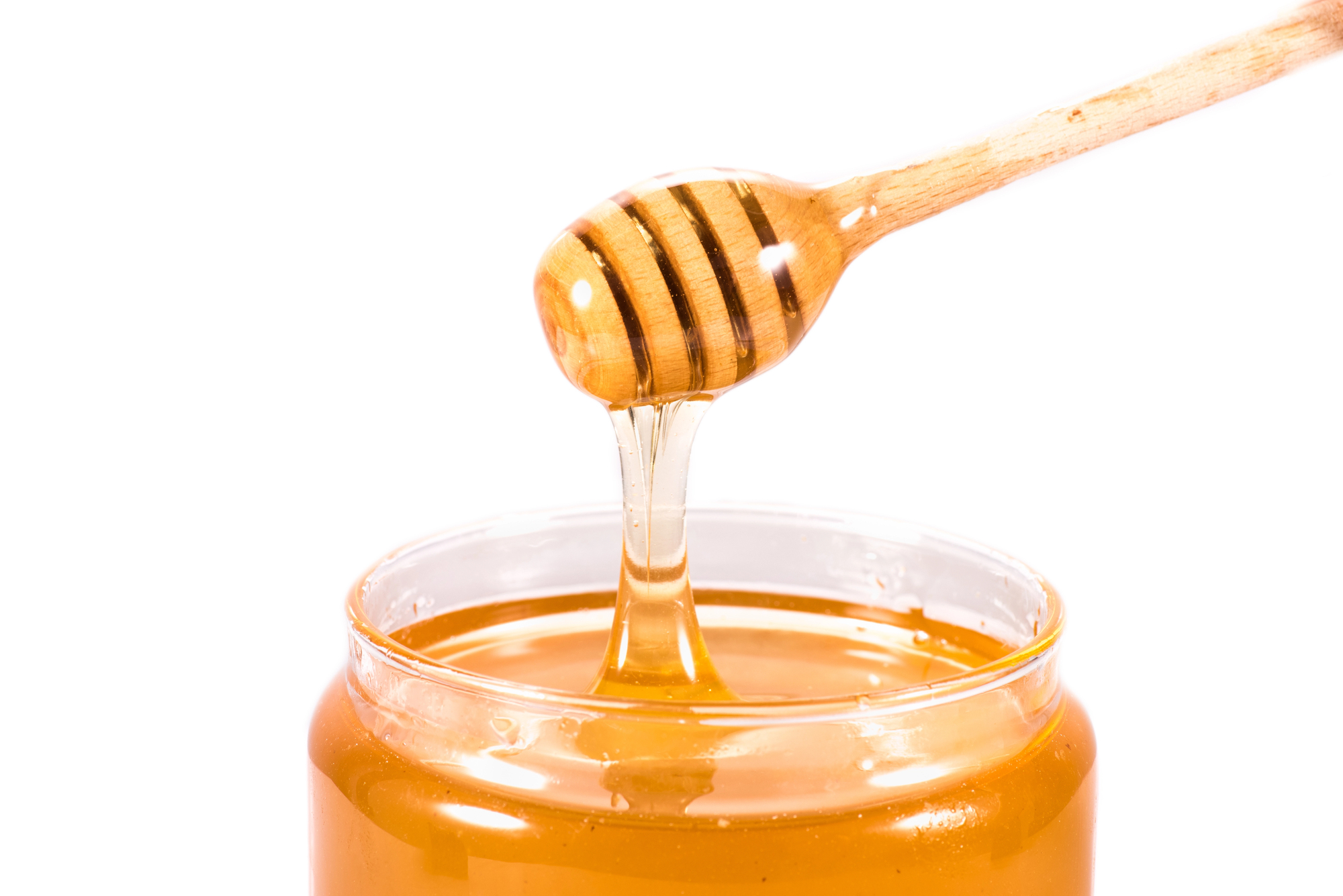 Honey dipper dipping honey into a jar/