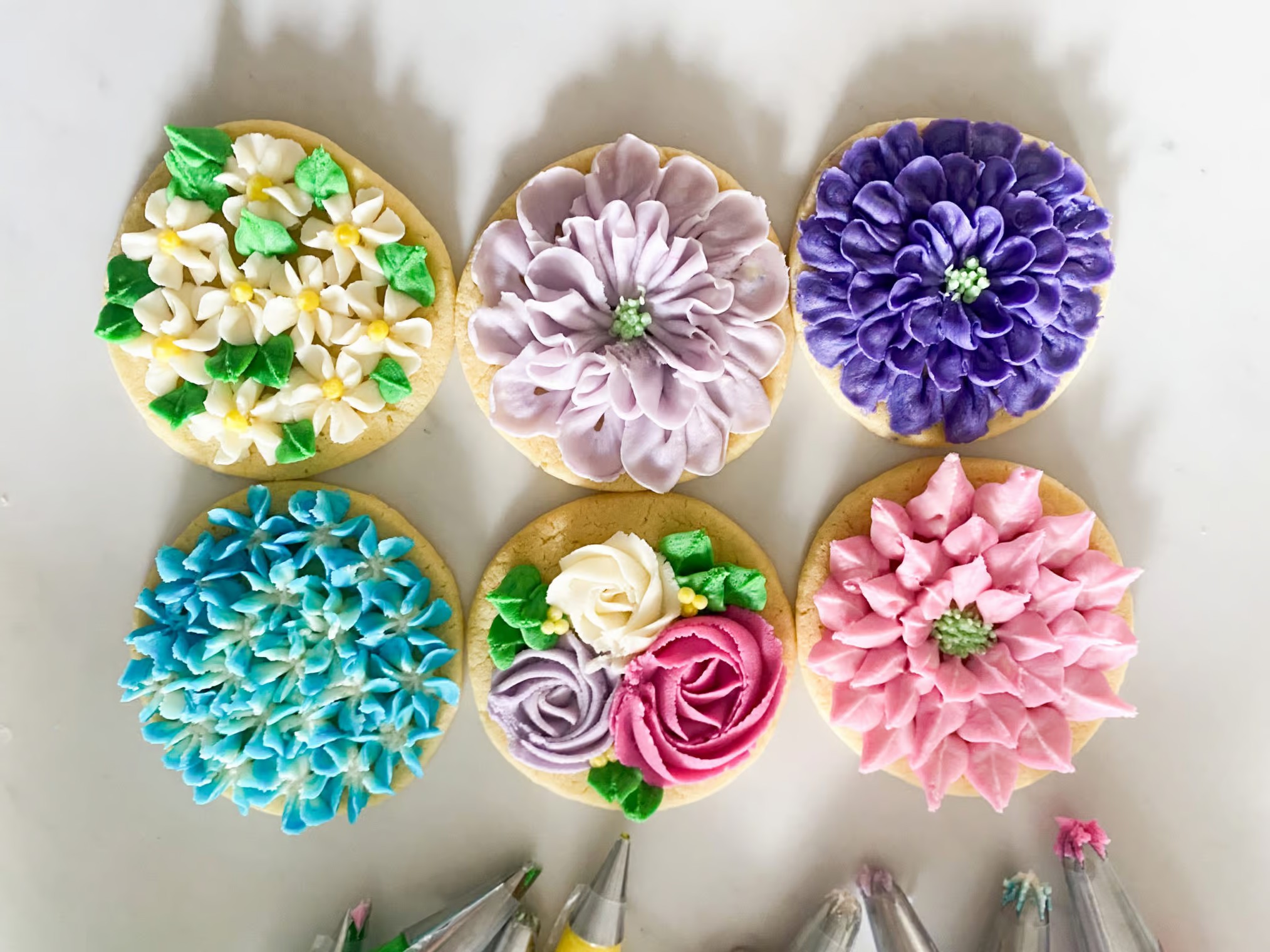 An overhead shot of six spring flower cookies