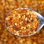 Bee bread pellets on a spoon.