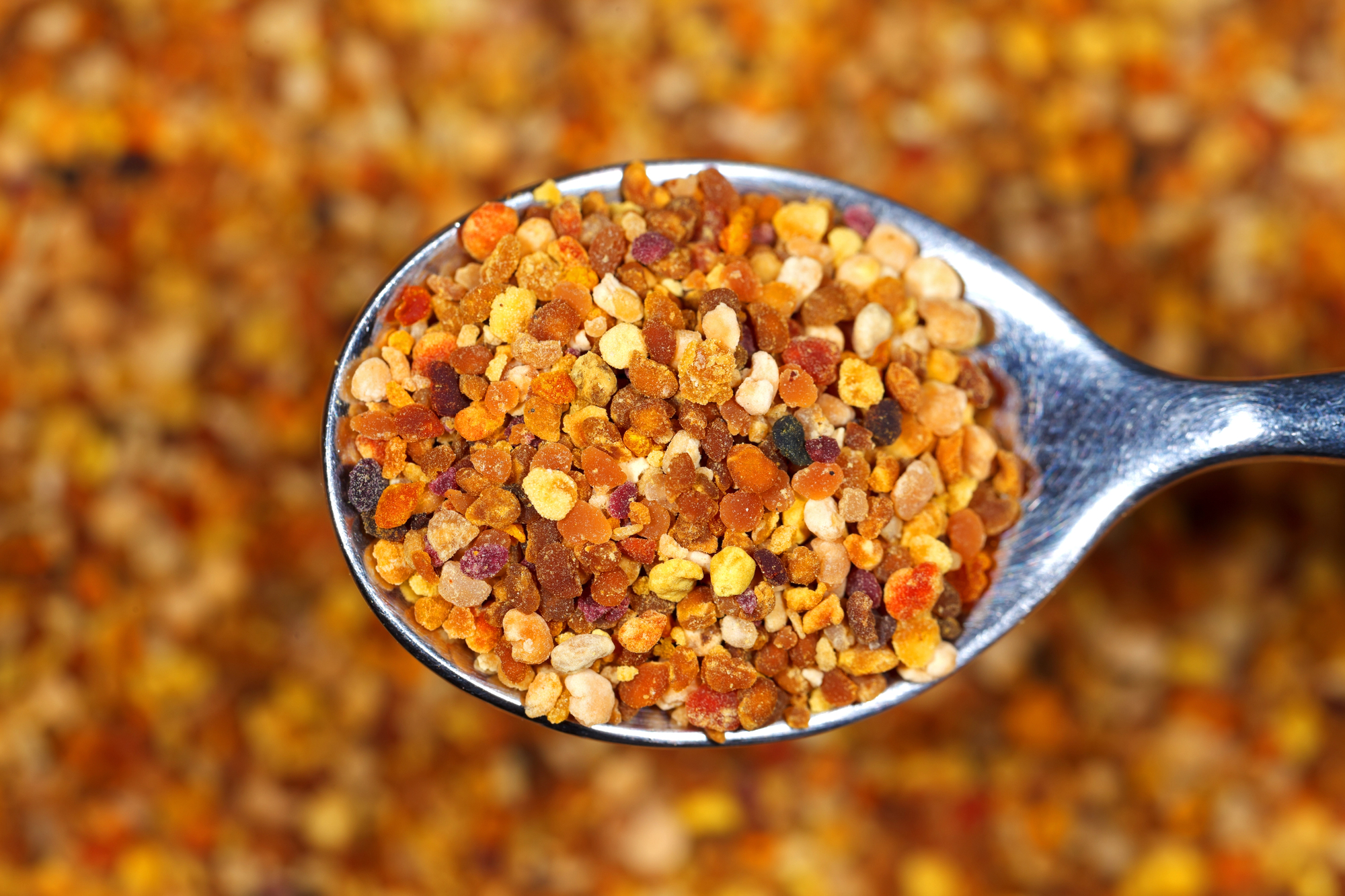 Bee bread pellets on a spoon.